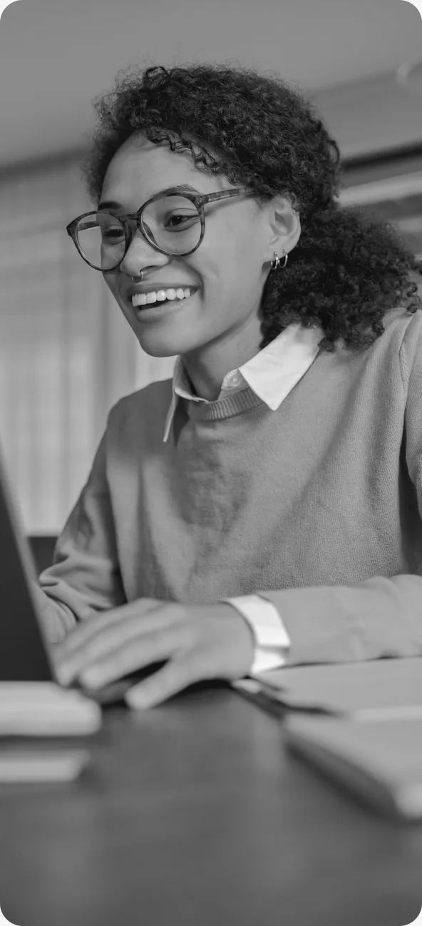 Estudante sorrindo usando notebook em sala