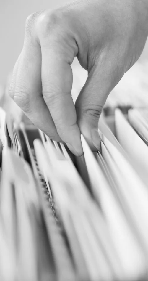 Mão consultando pastas de documentos